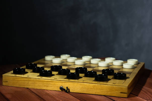 istock Chess board with chess on a red wooden table. Beautiful dark background Hobby. Checkers on the playing field for the game. 1060429628