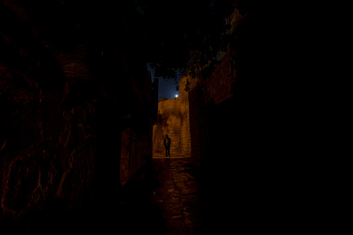 Man at narrow street at night of Mardin in Turkey