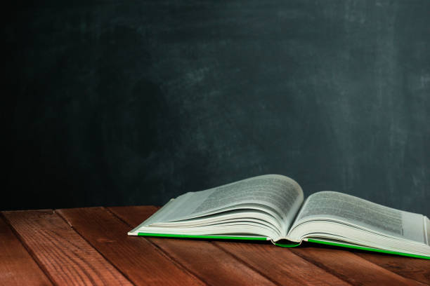 istock New books on a wooden red table. Beautiful dark background. 1060431568