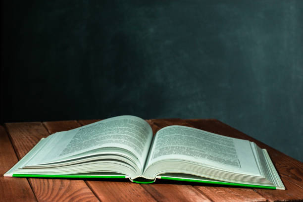 istock New books on a wooden red table. Beautiful dark background. 1060432128