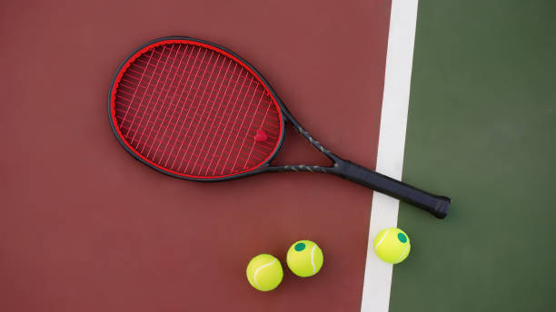 istock Tennis racket with balls on green and red background 1060432304