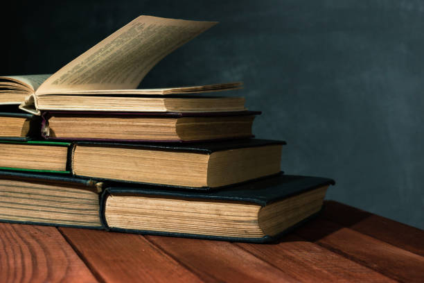 istock Old books on a wooden red table. Beautiful dark background. 1060432524