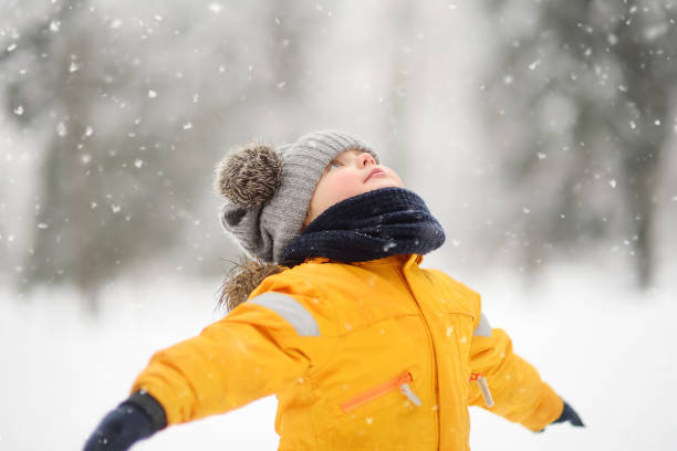 istock Cute little boy in yellow winter clothes walks during a snowfall 1060439096