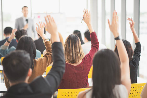 istock Seminar group raising up hand for asking the speaker in question and answer time in meeting room back side 1060441944