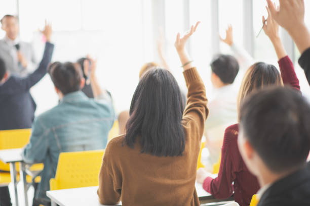 istock Seminar group raising up hand for asking the speaker in question and answer time in meeting room back side 1060442504