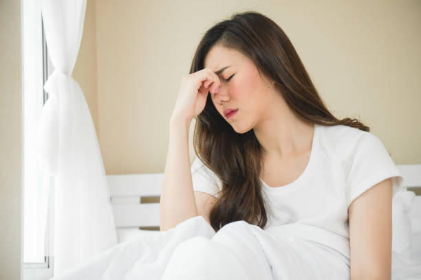 istock Asian woman have a headache in bedroom morning because sleep problem 1060445888