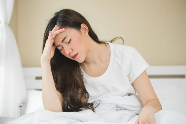 istock Asian woman have a headache in bedroom morning because sleep problem 1060446042