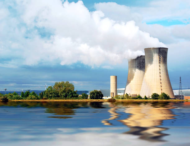 Nuclear plant. Chimneys of the plant emitting steam. The cooling is provided by the river water. nuclear reactor stock pictures, royalty-free photos & images