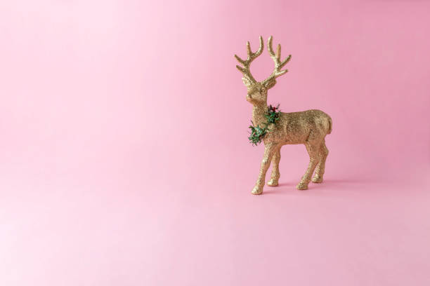 istock Gold glitter reindeer on pink background. Minimal New Year compo 1060452280