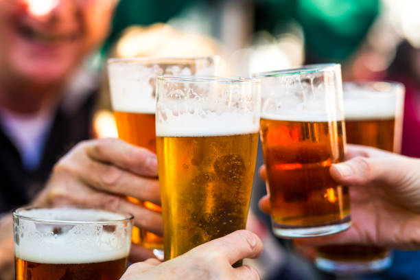 cheers viering toast met pinten bier - alcohol drinks stockfoto's en -beelden
