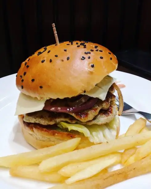 A cheese chicken burger with french fries as addon to the dish