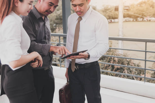 istock Group of business asian people standing and talking about summary report on tablet screen. 1060464532