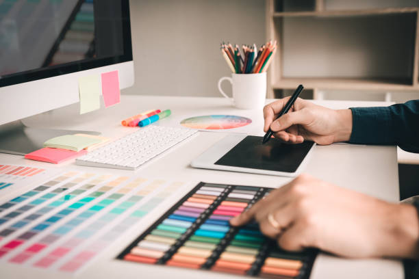istock Graphic designer working using digital graphic tablet with colour chart and digitizer at workplace 1060465950