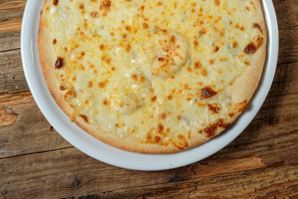istock Four cheese pizza quattro fromaggi on wood background.Top view 1060473474