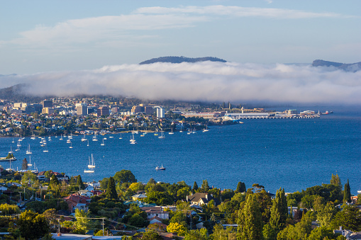 Hobart, Tasmania, Australia - December 24 2016: Hobart city and derwent river viewed from suburb of sandy bay with sea mist rolling over eastern shore