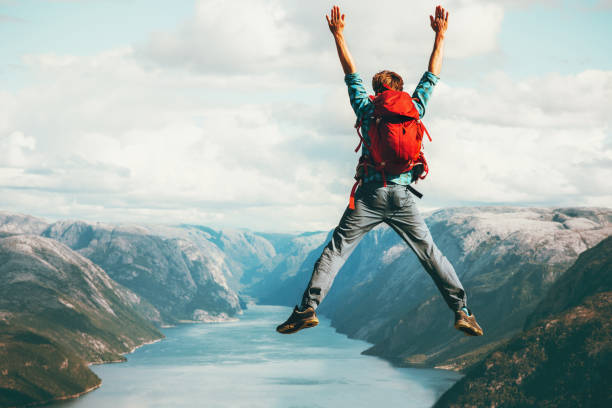 istock Happy Man jumping Travel Lifestyle adventure concept active summer vacations with backpack outdoor in Norway success and fun emotions above Lysefjord cliff 1060483820
