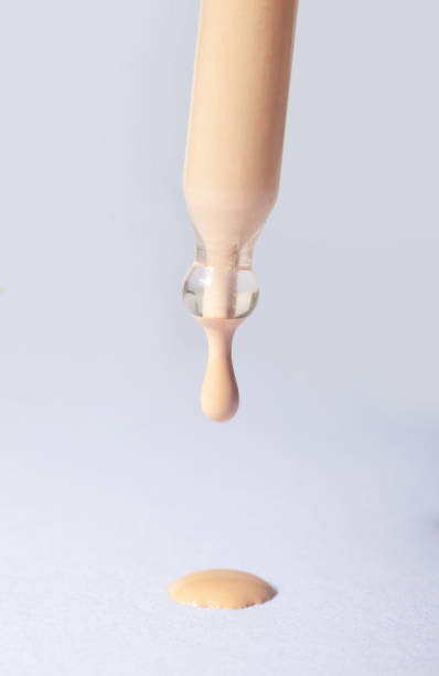 istock Drops of foundation falling on a gray background. 1060484104