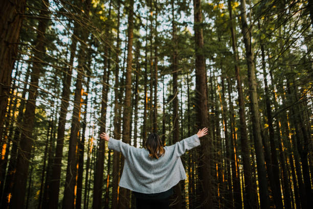 istock Young woman with arms raised by a forest 1060499178