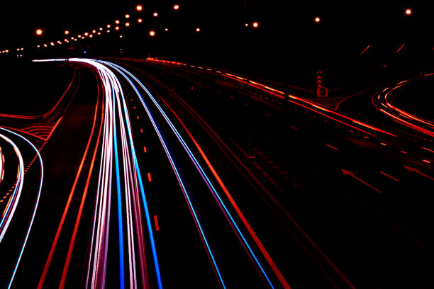 Cars light trails on a curved highway at night. Night traffic trails. Motion blur. Night city road with traffic headlight motion. Cityscape. Light up road by vehicle motion blur. luz de coches pistas en una carretera de curva por la noche. rutas de tráfico de noche. desenfoque de movimiento. calle de la ciudad de noche con movimiento de faro de tráfico. paisaje urbano. camino de la luz por desenfoque de movimiento del vehículo.