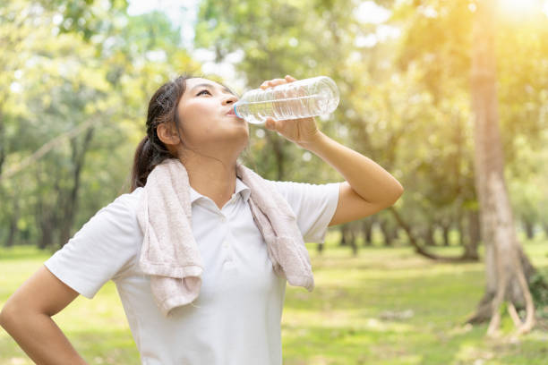 istock sporty man thirsty and drinking water after tired from jogging or exercise. 1060515018