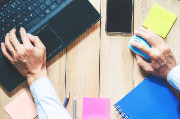 istock business man working with laptop on wood table with sticky note or post note, pencil, calendar and notebook. flat lay working desk. working at home, education, learning online and home work concept. 1060516296