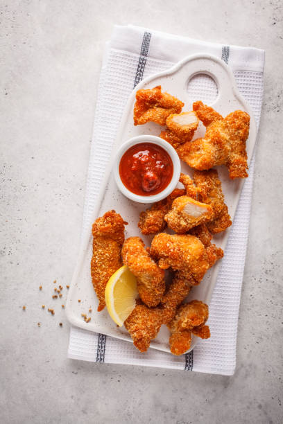 istock Fried Breaded chicken with tomato sauce on a white board, top view. 1060519114