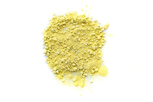 Yellow color background of chalk powder. Yellow color dust particles splattered on white background.
