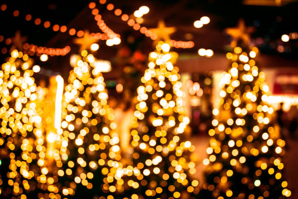 istock Christmas tree with gold bokeh light background. Xmas abstract blur and glowing decorations outdoors. 1060539664