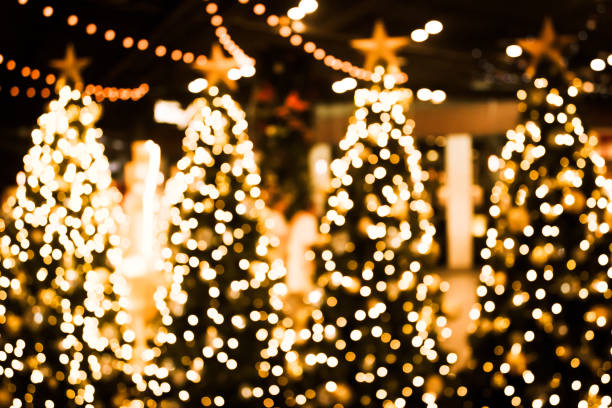 istock Christmas tree with gold bokeh light background. Xmas abstract blur and glowing decorations outdoors. 1060539682