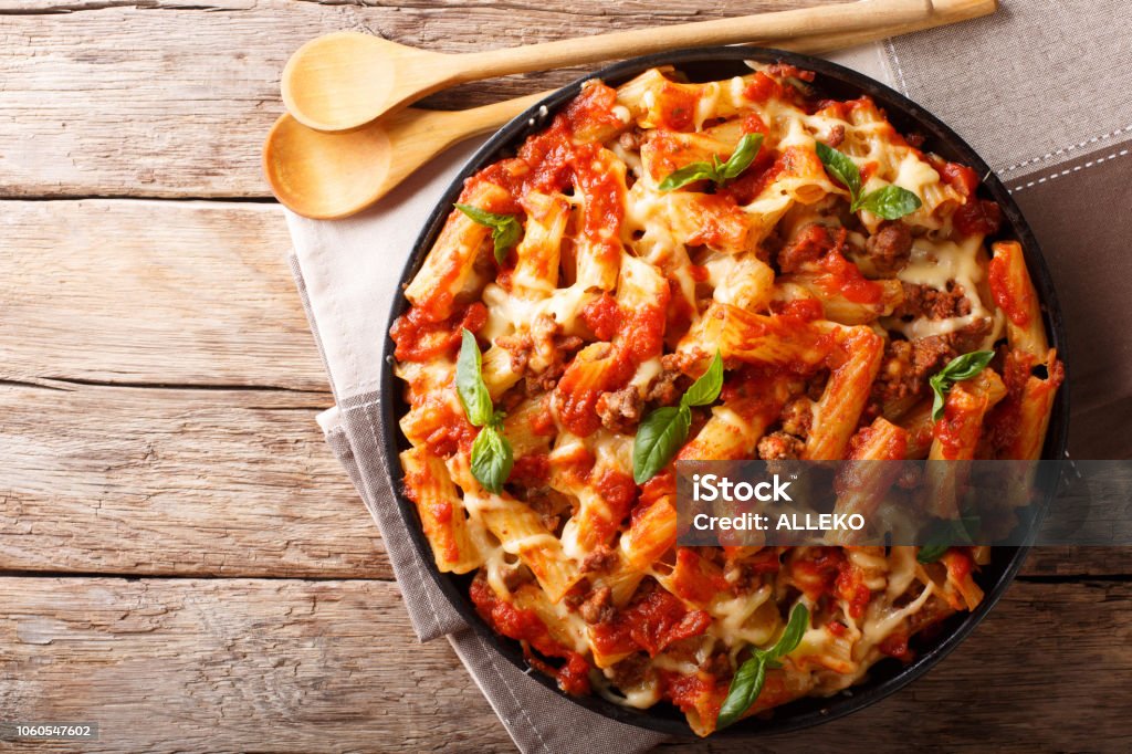 Pasta ziti with bolognese sauce and cheese close-up. horizontal top view, rustic style Pasta ziti with bolognese sauce and cheese close-up on the table. horizontal top view from above, rustic style Baking Stock Photo
