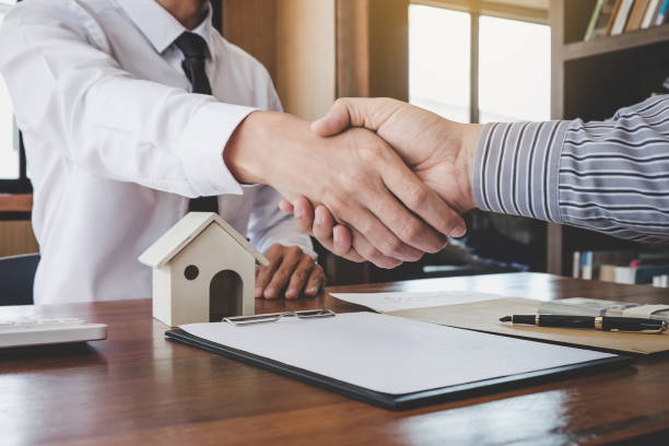 istock Real estate broker agent and customer shaking hands after signing contract documents for realty purchase, Bank employees congratulate, Concept mortgage loan approval 1060553628