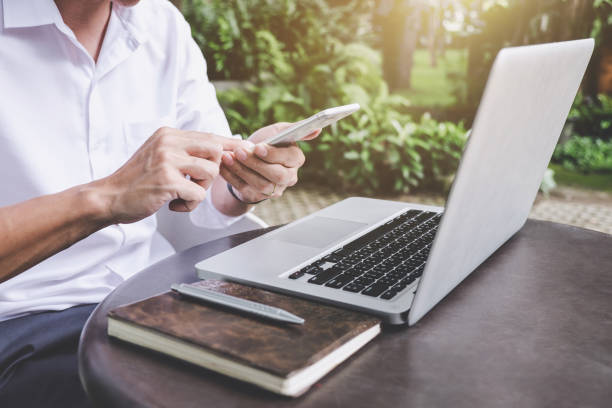 istock Image of businessman working with laptop and analysis financial document data on smartphone in outdoor office, finance,investment, business concept and Accounting,Economic,commercial 1060554654