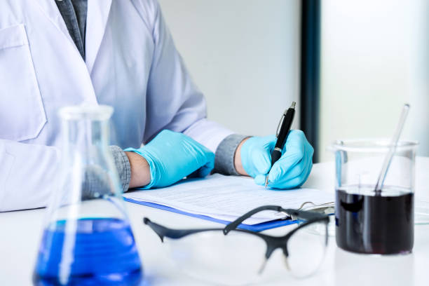 istock Biochemistry laboratory research, Chemist is analyzing sample and record in laboratory with equipment and science experiments glassware containing chemical liquid 1060555248