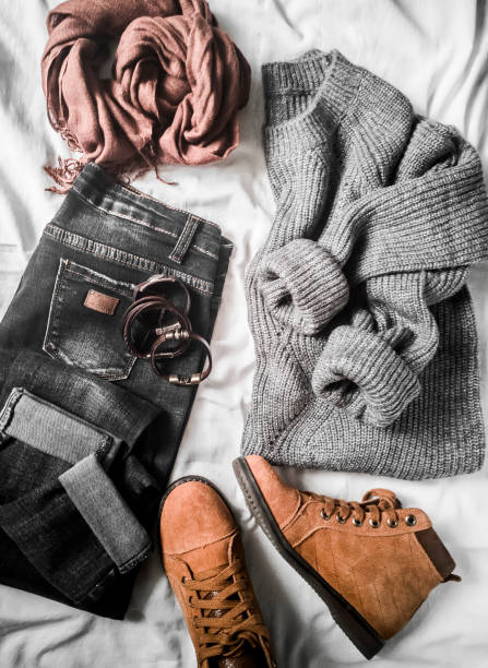 istock Set of women's autumn, winter clothes on a light background - jeans, gray pullover oversize, suede brown boots and scarf. Fashionable clothes for walks, flat lay 1060555418