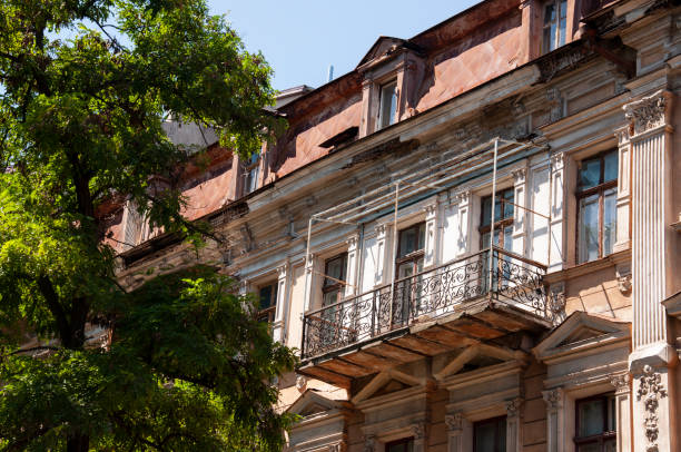 histórica casa de pedra antiga no pátio com árvores ao redor. antigos edifícios da cidade antes e depois restavration. janelas antigas, telhados, varandas. esculturas, paredes sul, verão - restavration - fotografias e filmes do acervo