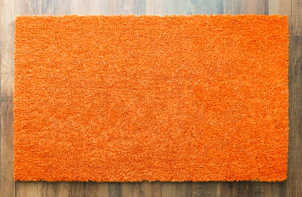 istock Blank Orange Welcome Mat On Wood Floor Background Ready For Your Own Text 1060557476