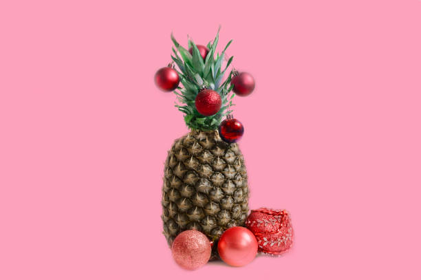 istock pineapple with Christmas decorations on a pink background 1060557536