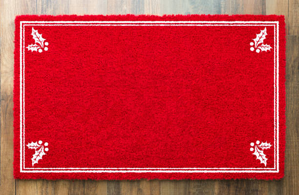 tappeto di benvenuto rosso vacanza vuoto con angoli agrifoglio su sfondo pavimento in legno - welcome sign doormat greeting floor mat foto e immagini stock