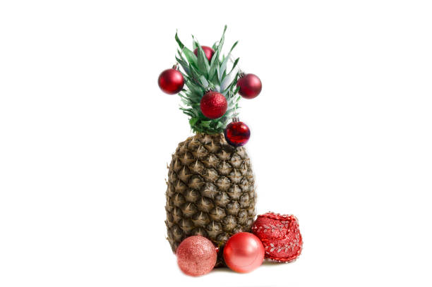 istock pineapple with Christmas decorations on a white background 1060557686