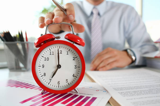 istock Male hand on the alarm clock a red 1060558184