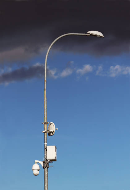 istock Surveillance system with an orange warning light located on a pole in the open. The threat of privacy and the protection of personal data. Security tracking on the streets of the city. Human mass 1060562074