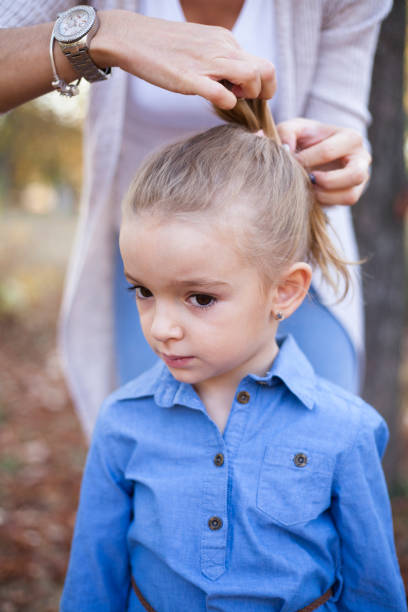 istock mother making daughter's hair 1060568960