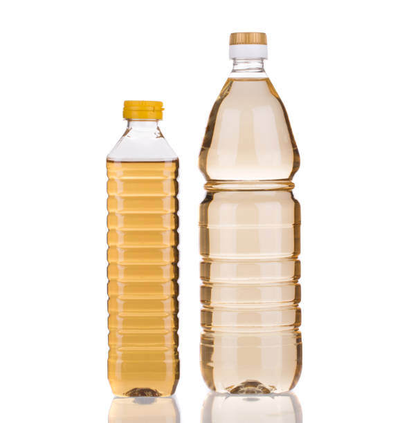 Two bottles of vinegar. Two bottles of vinegar. It is isolated in a white background. Close-up. vinegar bottle stock pictures, royalty-free photos & images