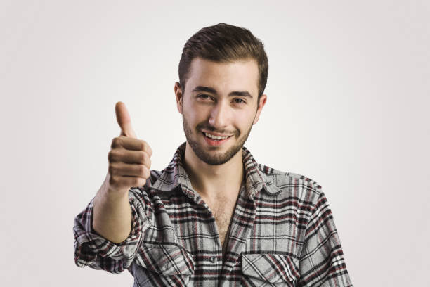 istock Confident handsome young man showing thumbs up in foreground 1060582752