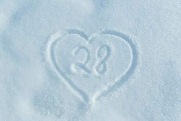 Photo of A figure of Twenty eight written in the snow in the painted heart.