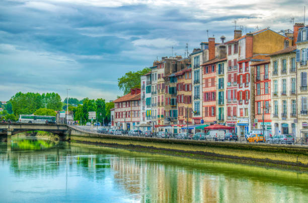 Riverside of Nive flowing through Bayonne, France Bayonne, France, May 16, 2017: Colourful buildings situated on riverside of Nive flowing through Bayonne, France bayonne stock pictures, royalty-free photos & images