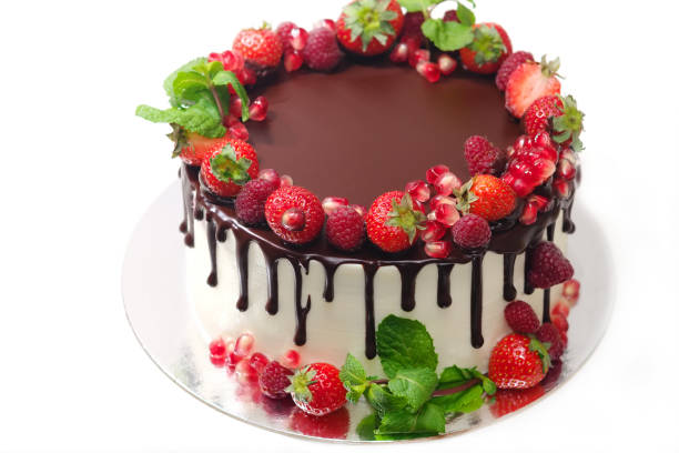 istock cake covered with berries of raspberry strawberry pomegranate mint leaves doused with chocolate on an isolated white background 1060586098