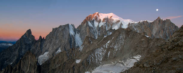 Mont Blanc , mont Maudit, Mont Blanc du Tacul , mountain range at Sunrise with alpenglow and moon over mont blanc du Tacul Mont Blanc , mont Maudit, Mont Blanc du Tacul , mountain range at Sunrise with alpenglow and moon over mont blanc du Tacul dent du geant stock pictures, royalty-free photos & images