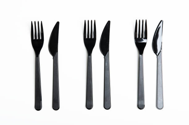 istock Clean plastic black forks and knives on white background. Disposable dishes, environmental pollution. Top view, flat lay. 1060591448