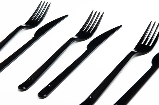 istock Clean plastic black forks and knives on white background. Disposable dishes, environmental pollution. 1060591466